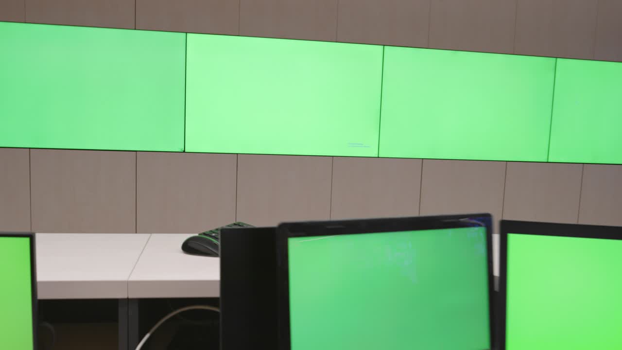 especialista en seguridad de sistemas que trabaja en el centro de control de sistemas. la habitación está llena de pantallas verdes, pantallas cromáticas y seguridad