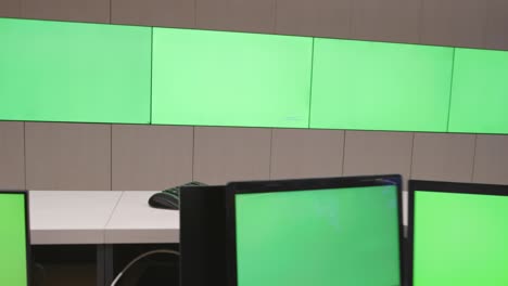 system security specialist working at system control center. room is full of green screens, chroma screen and security