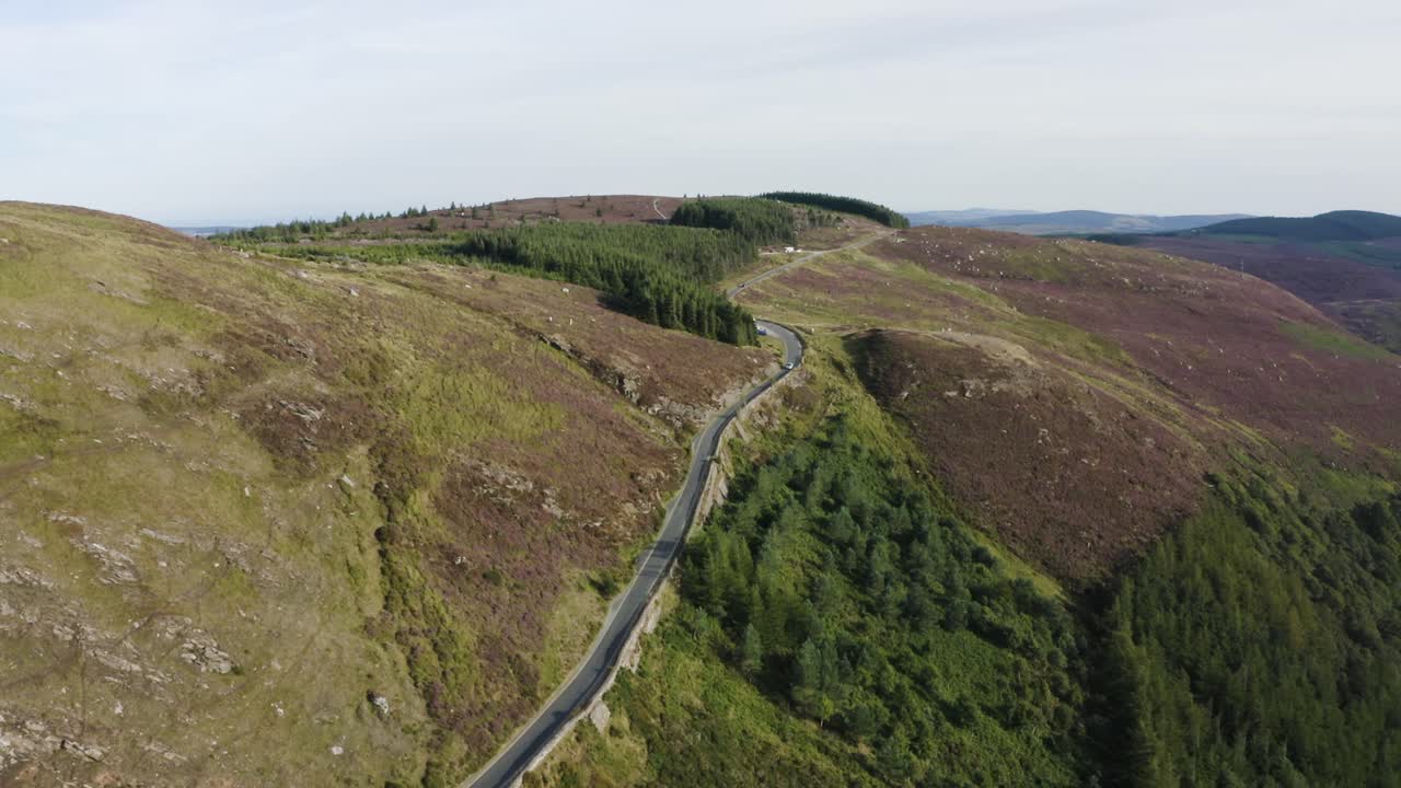 vista aérea de los coches que circulan por una larga y sinuosa carretera de montaña en las montañas de wicklow en un día soleado-1