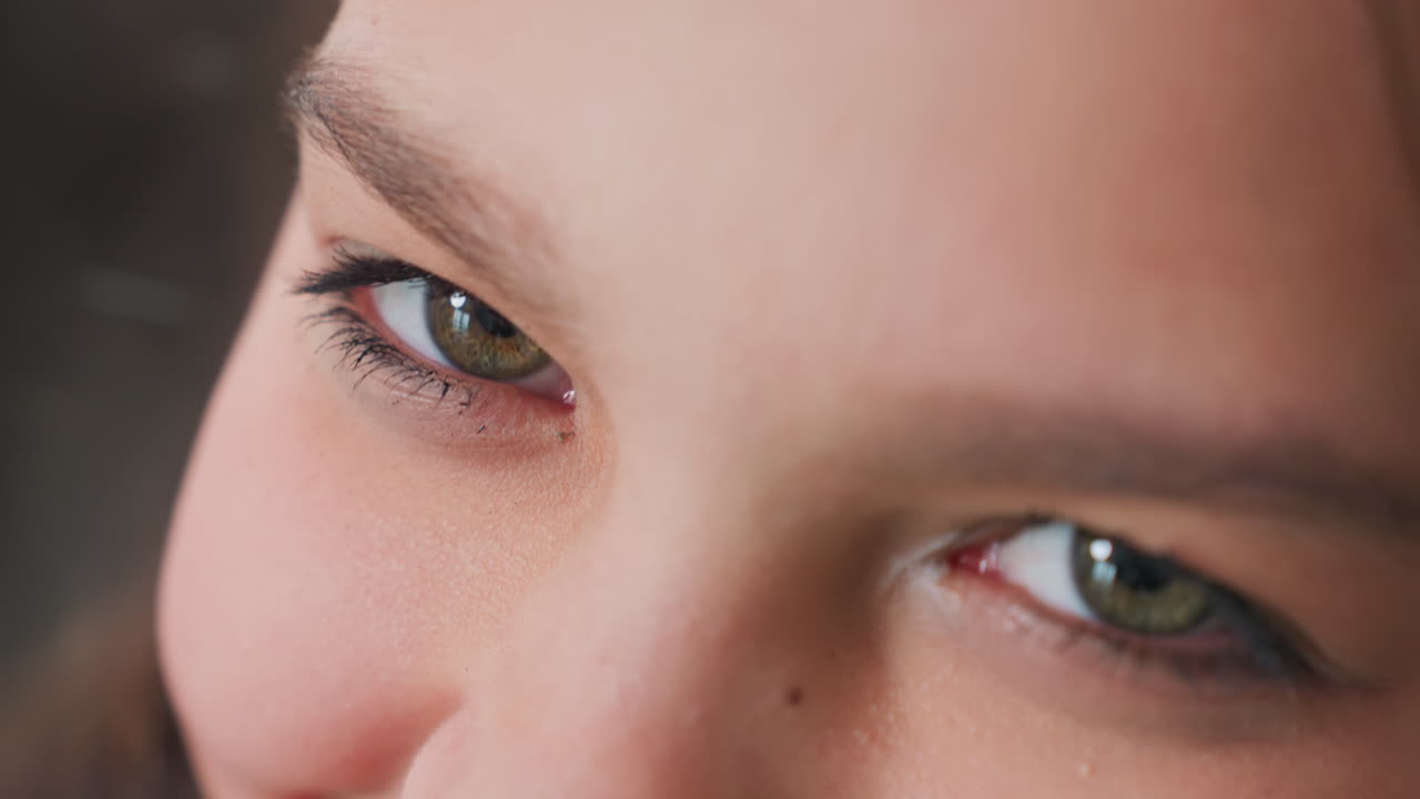 extreme close up of young woman kissing finger with soft skin detail visible, natural lighting highlighting lips and fingers, intimate moment with shallow depth of field and neutral background