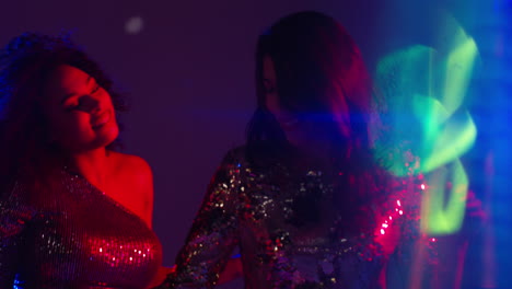 close up of two women in nightclub bar or disco dancing with sparkling lights 18