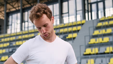 close up of a fitness male athlete warming up and stretching neck in the stadium