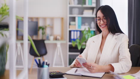 una mujer de negocios feliz usa un teléfono inteligente para administrar negocios en línea