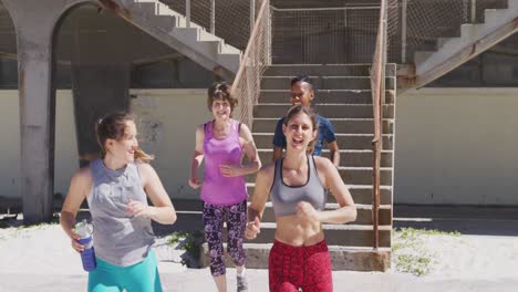 Grupo-Multiétnico-De-Mujeres-Corriendo-En-La-Playa-Y-El-Fondo-Del-Cielo-Azul