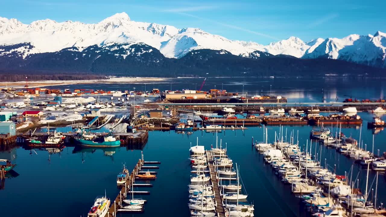 video de drones de 4k del puerto de barcos de seward y las montañas cubiertas de nieve circundantes en un día nevado de invierno en alaska