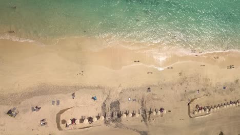 Sonnenschirm-Und-Touristen-Beim-Sonnenbaden-In-Spanien,-Kanarische-Insel-Fuerteventura,-Luftaufnahme-Von-Oben-Nach-Unten,-Blick-Auf-Den-Atlantischen-Ozean