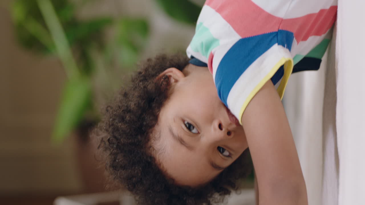 niño feliz jugando en el sofá en casa sonriendo disfrutando del juego despreocupado de la infancia