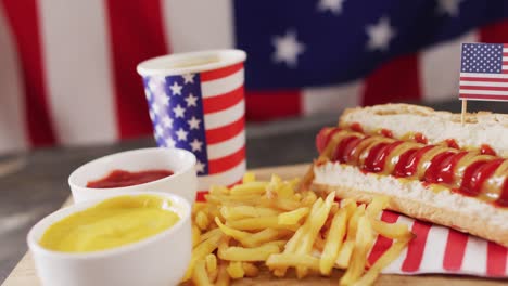 video of hot dogs with mustard, ketchup and chips over flag of usa on a wooden surface