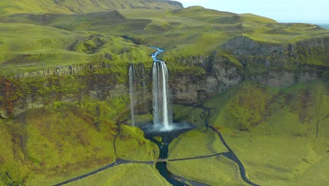 Grüne-Malerische-Seljalandsfoss-Wasserfalllandschaft,-Unglaubliche-Aussicht-Auf-Ein-Naturdenkmal,-Statische-Drohnenaufnahme