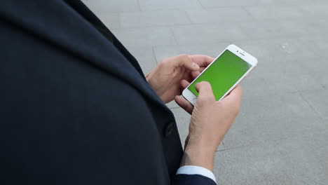 businessman typing on smartphone on street. entrepreneur using phone outside