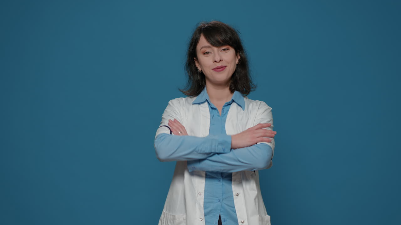Portrait of female chemist with white coat standing in front of camera