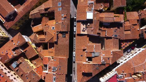 top down view flying above roofs, roads and city on a sunny day in florence in italy in 4k