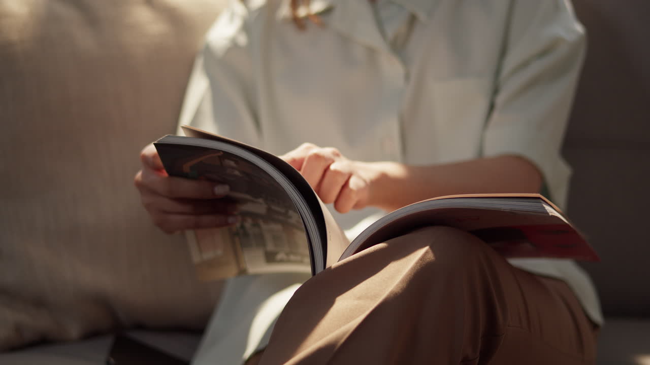 A person enjoys a magazine in a cozy living room capturing a moment of relaxation and leisure.