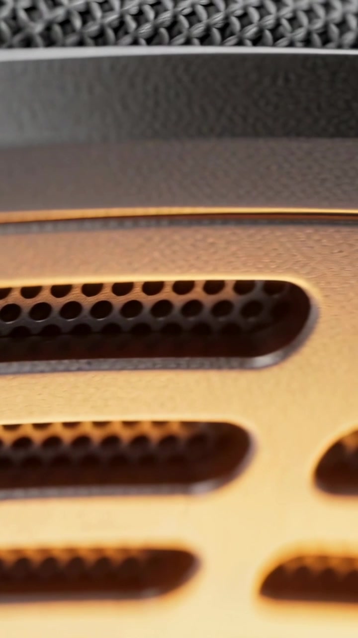 Vertical video: Camera panning speaker grille revealing left screw, rim and fabric showing detail