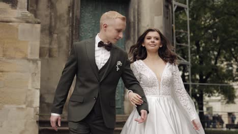 newlyweds, caucasian groom with bride walking, embracing, hugs in city, wedding couple in love