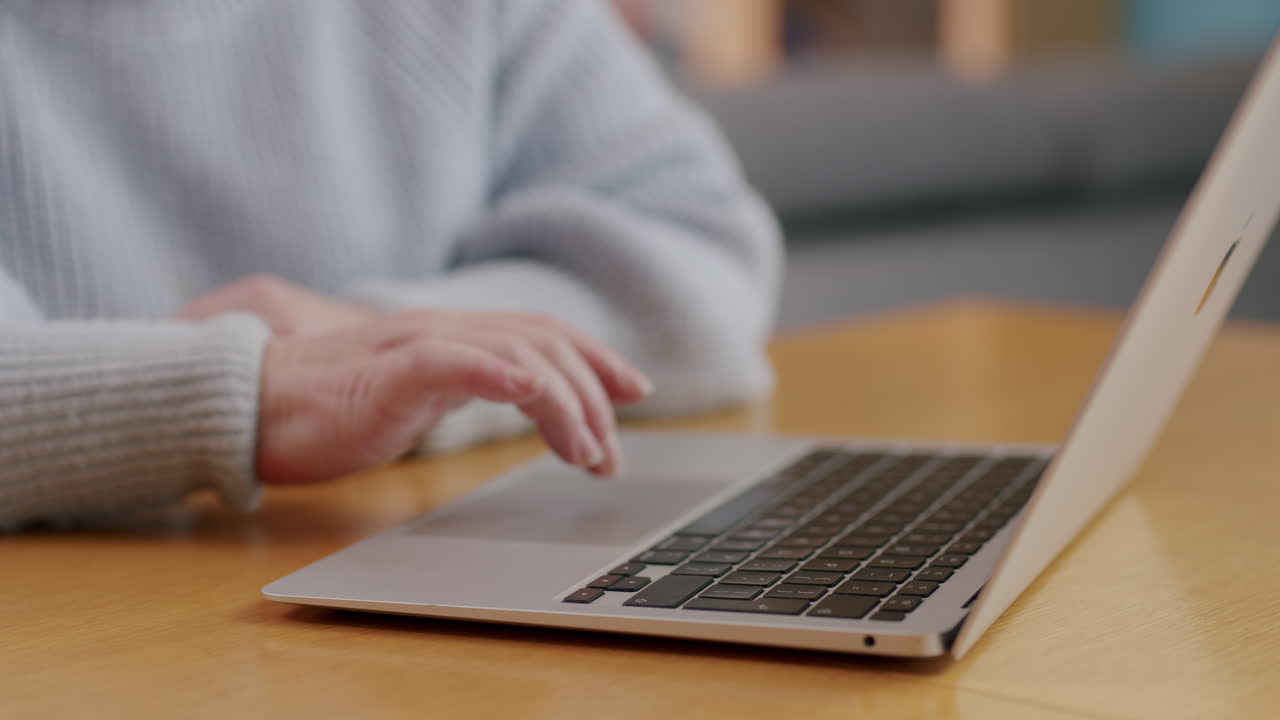 노트북을 사용하여 인식할 수 없는 백인 여성의 손, 가까운 측면 보기