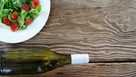 salad with bottle on wooden table