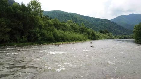 canadian mountain river man resting sitting by a stormy river canadian mountain river man resting sitting by a stormy river tent by the river above