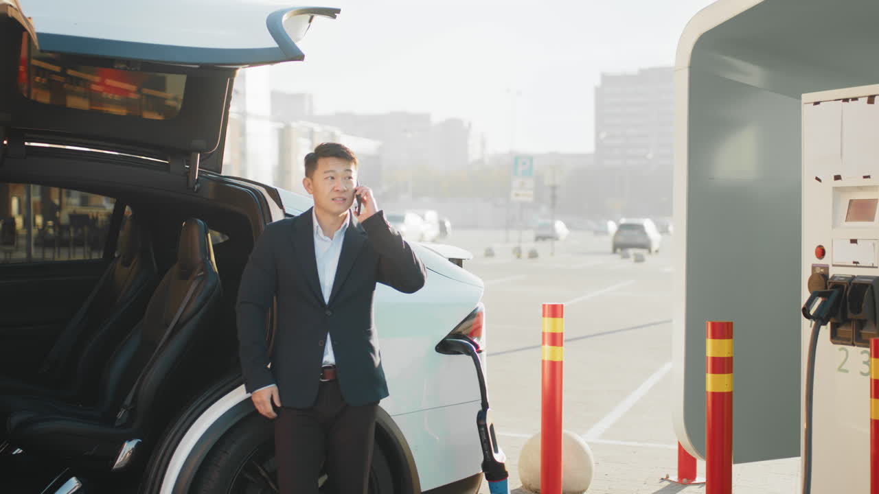 충전소 에서 전기 차량 을 충전 하는 사업가