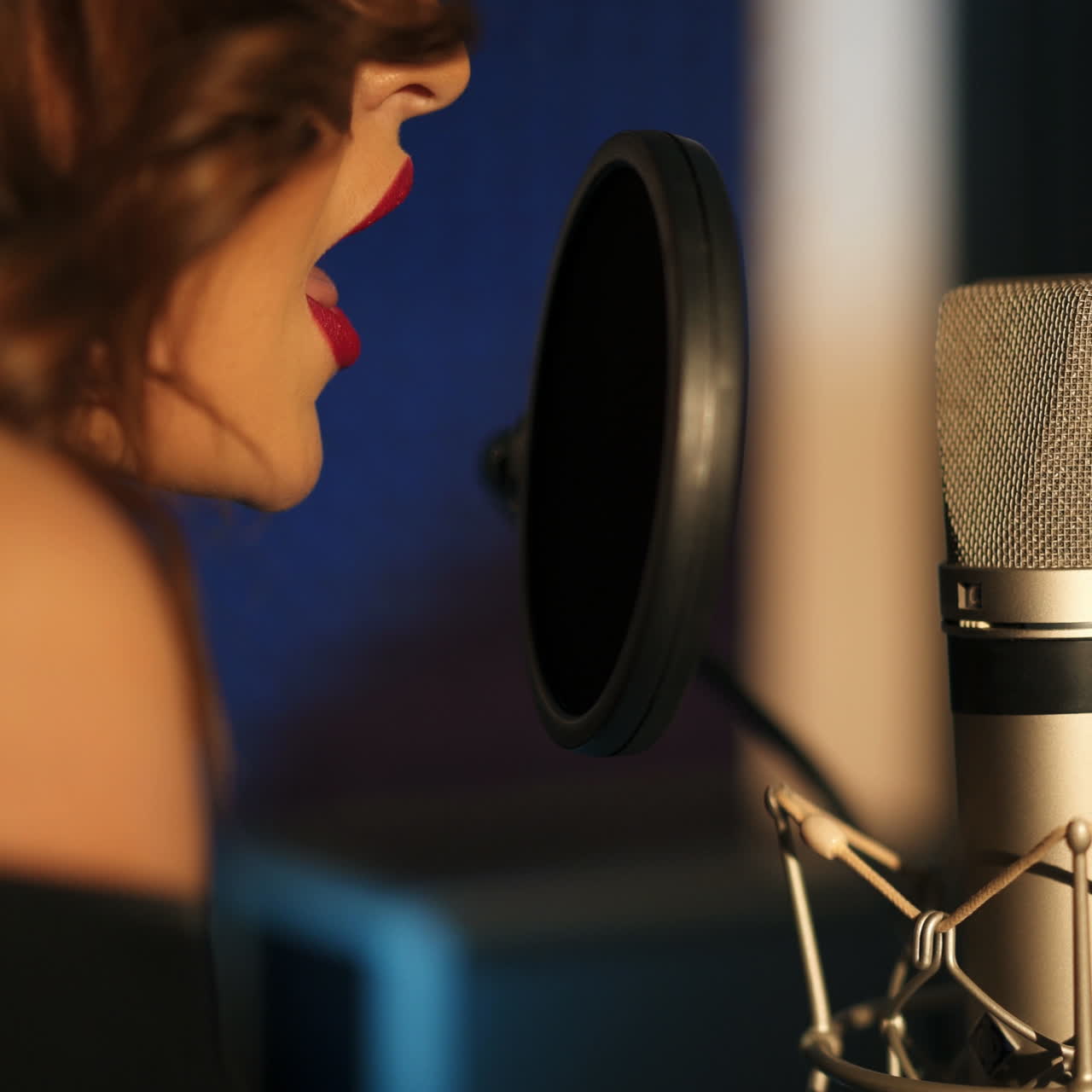Young woman recording a song in a professional studio. Close-up face. Square video