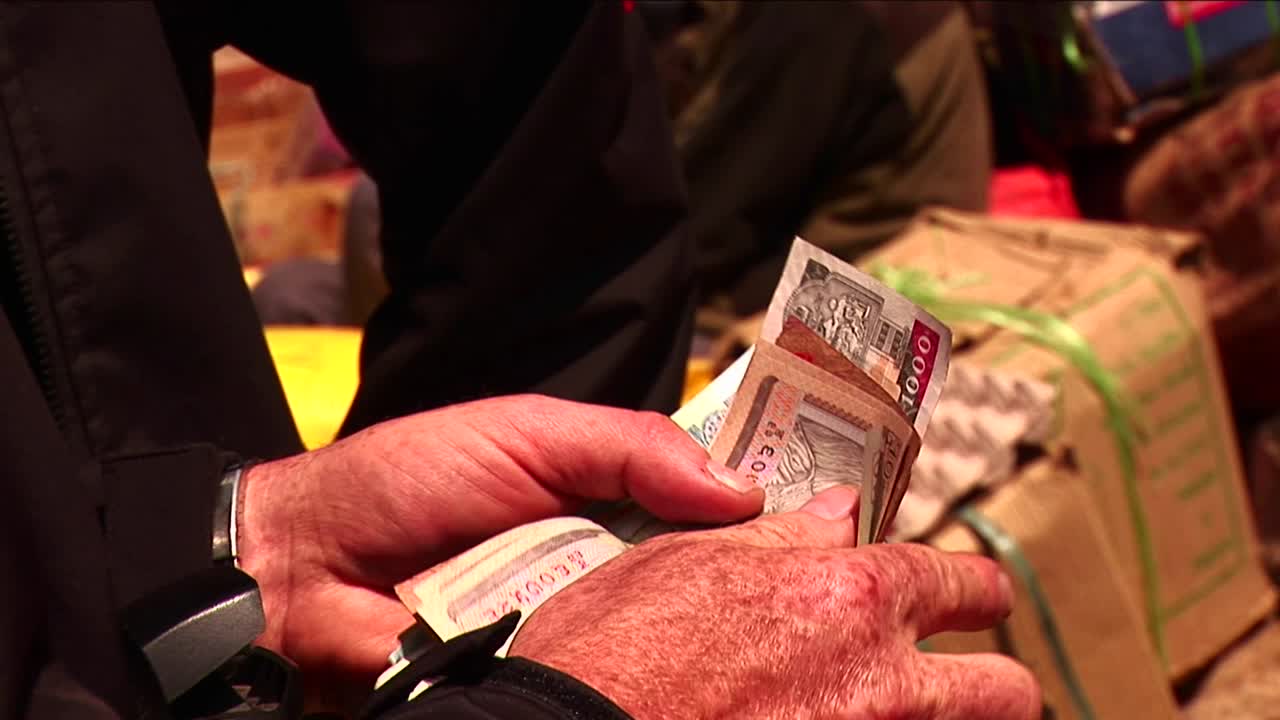 contando dinero para dar al proveedor en un mercado del himalaya