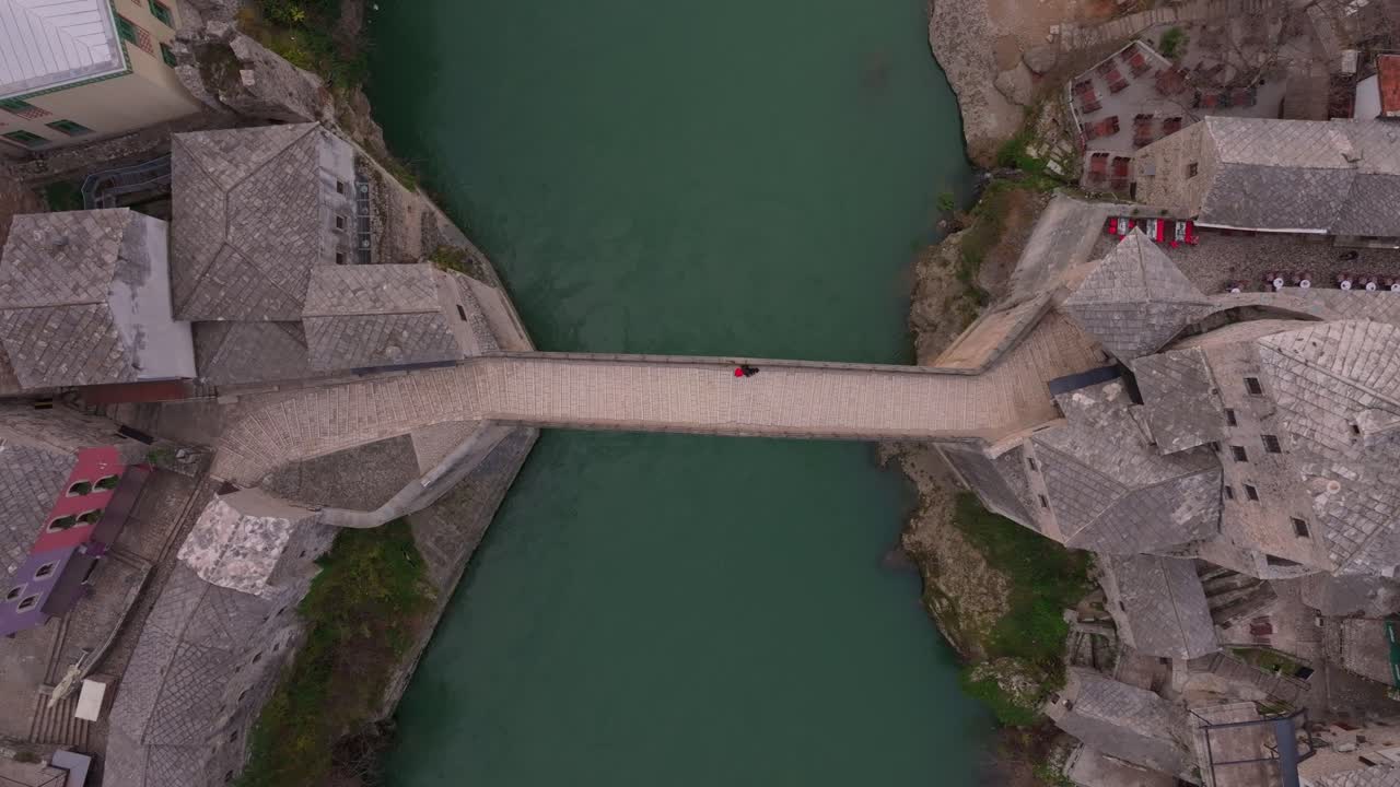 Escena aérea de Stari Most proyectando largas sombras sobre el río Neretva.