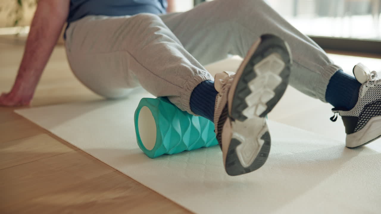 Close-up of Person Using Foam Roller on Leg Muscles