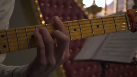 close-up of hands playing an electric guitar