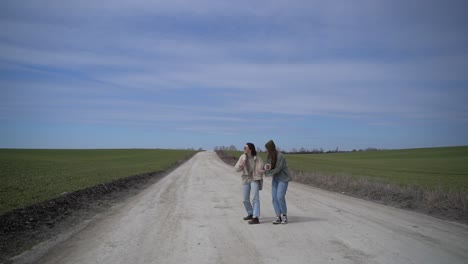 twee jonge meisjes die wankelend spelen midden op een verdwaalde weg op het platteland.