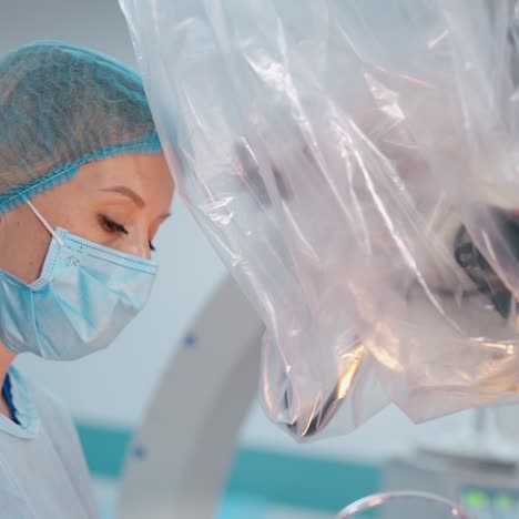 portrait of a female doctor at work. side view of a woman in medical mask near the modern medical equipment in hospital.