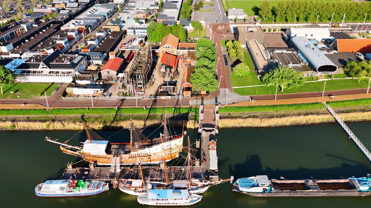 Flying over the wharf and museum Batavialand in Lelystad, the Netherlands. Reconstruction of 17-century ship Batavia and other boats are standing at the berth.