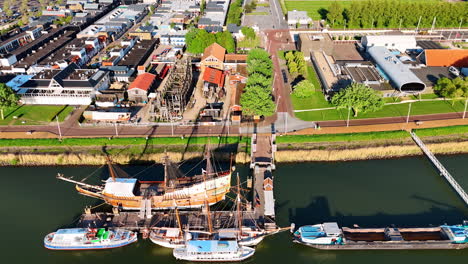 flying over the wharf and museum batavialand in lelystad, the netherlands. reconstruction of 17-century ship batavia and other boats are standing at the berth.