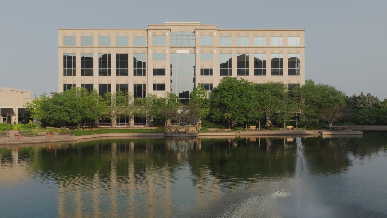 Moving aerial view of Centennial Lakes Office Park building on a sunny day in Edina, USA.