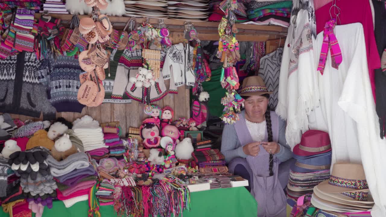 fotografía de la mujer tradicional (cholita) tejiendo en el mercado de recoleta, sucre