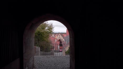 a drone flies backwards through a short tunnel on a bridge