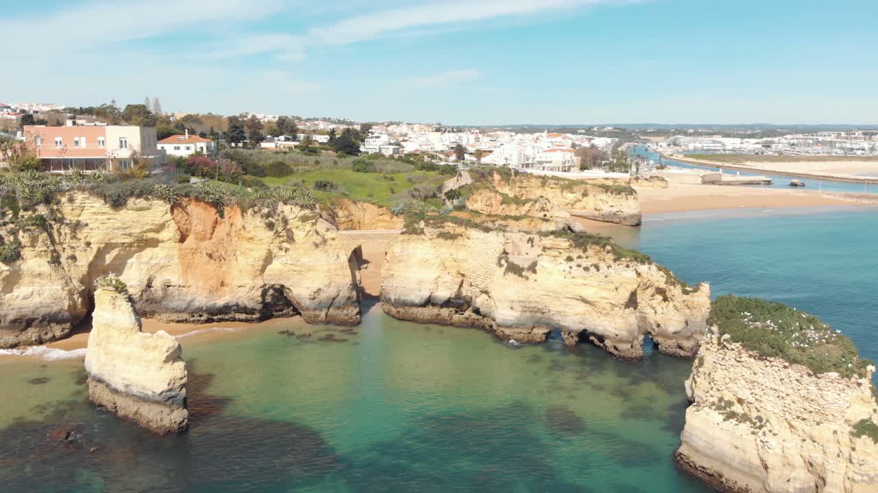Puente Romano de Lagos conectando acantilados sobre la playa, Algarve, Portugal