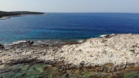 Turquoise-Water-And-Rocky-Coast-Of-Paralia-Emplisi-Beach-In-Greece---aerial-drone-shot