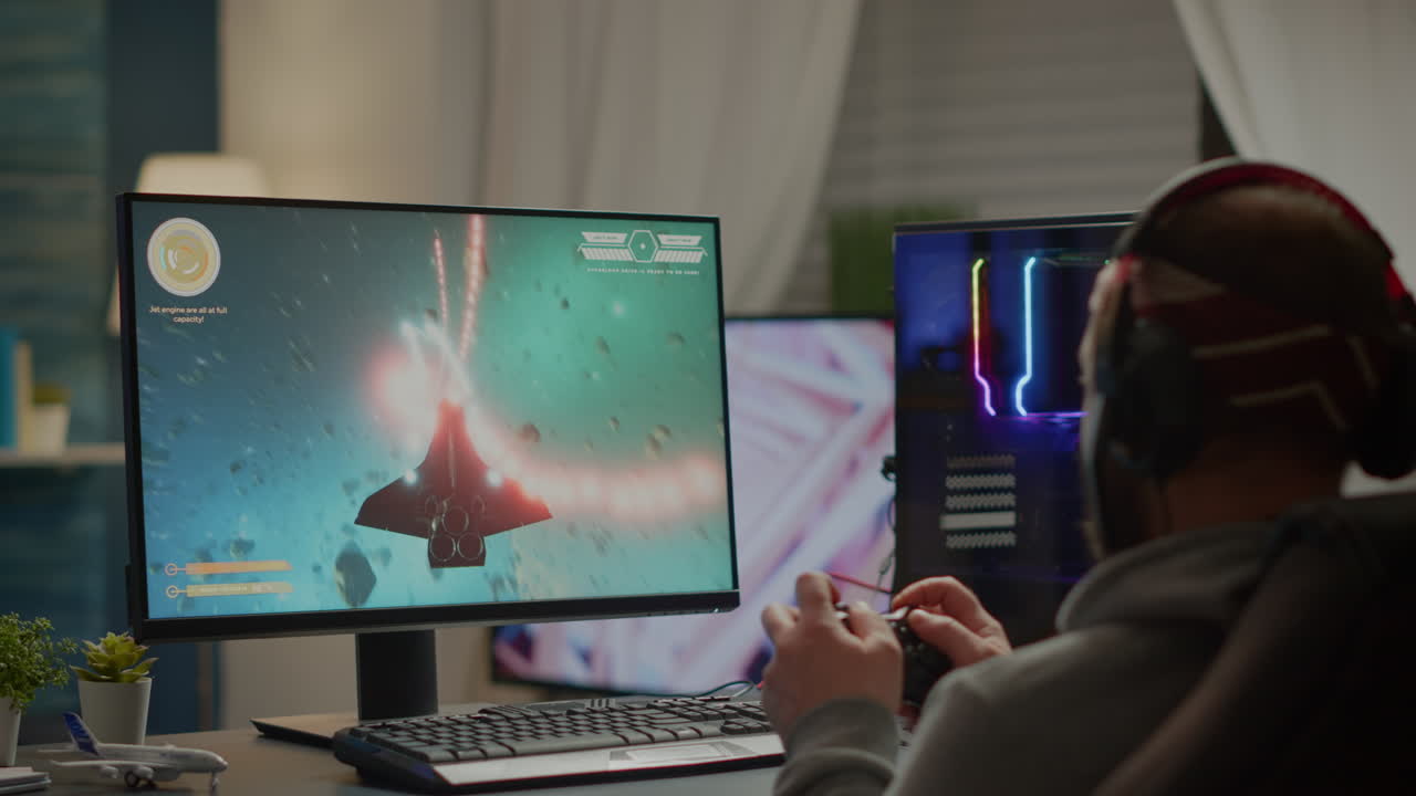 헤드폰과 조이패드를 가진 게이머 플레이어가 우주 슈팅 비디오 게임을 수행합니다.