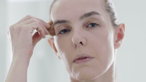 Closeup-woman's-face-putting-makeup-on.