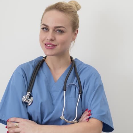 female doctor in blue medical coat standing isolated with arms crossed  looking at camera