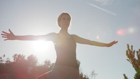 yong-frau, die draußen yoga macht, mit starkem sonnenlicht hinter ihr