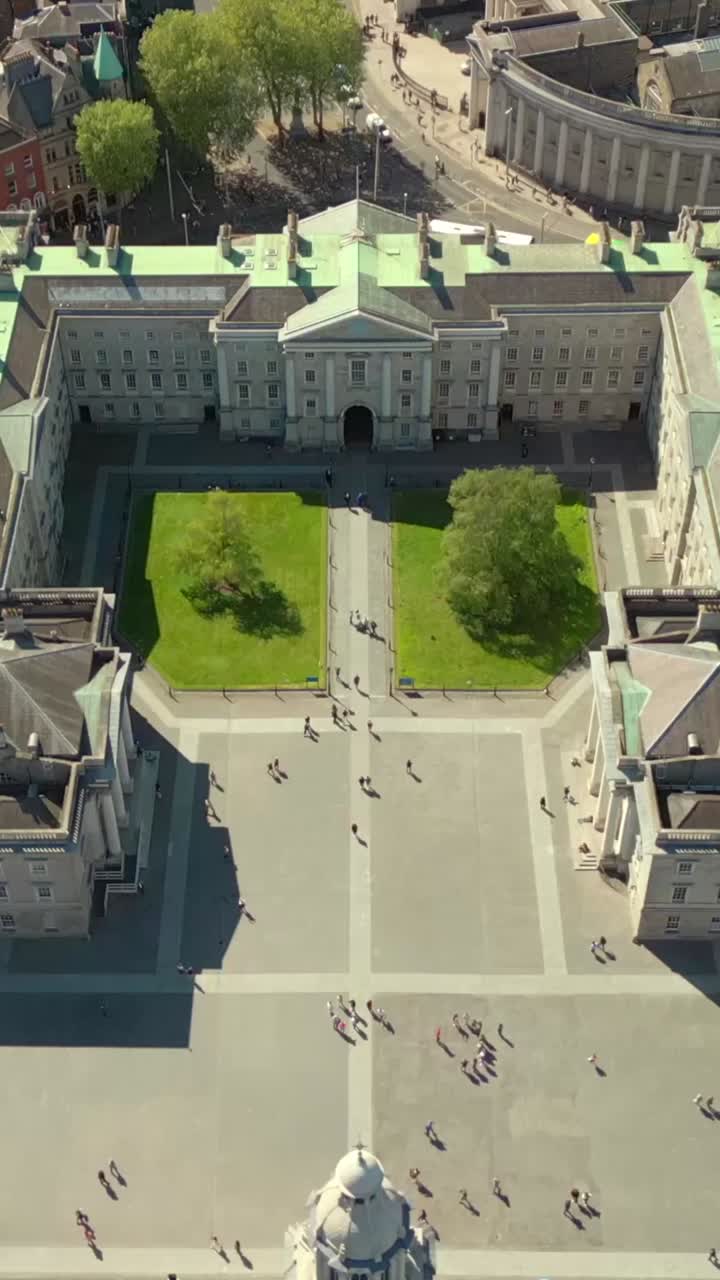 Reversing overhead social ratio aerial video of the grounds of Trinity College Dublin on a bright and sunny day. Filmed in 1080x1920 and with Rec709 color
