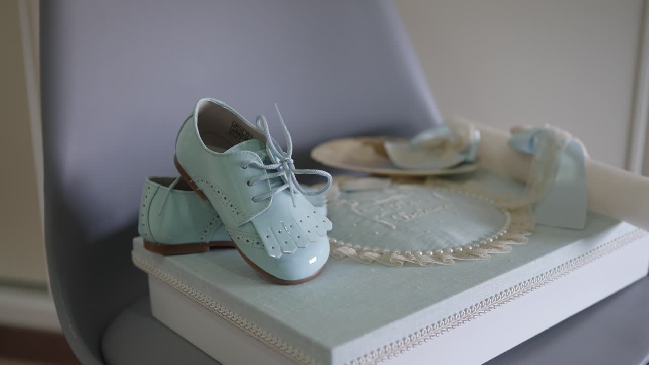 soft blue baby shoes on decorated box with baptism details