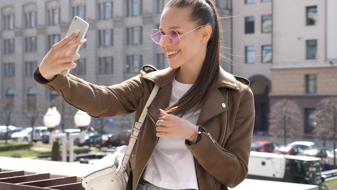 una mujer joven tomando una selfie en la ciudad.