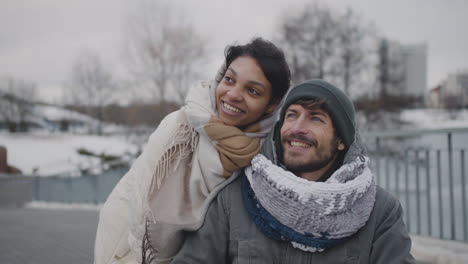 muslim woman and her disable friend looking at something in the sky in city in winter 1