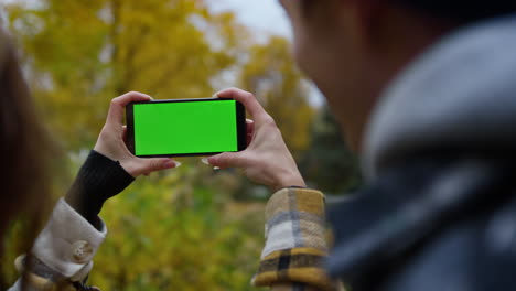 Nahaufnahme-Eines-Smartphones-Mit-Grünem-Bildschirm-In-Den-Händen-Von-Mädchen.-Mädchen-Benutzt-Mobiltelefon