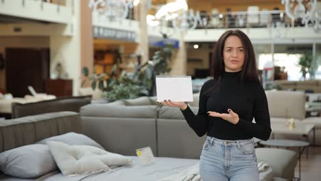 a beautiful woman seller in a furniture store holds a sign with discounts black friday a beautiful woman seller in a furniture store holds a sign with discounts black friday