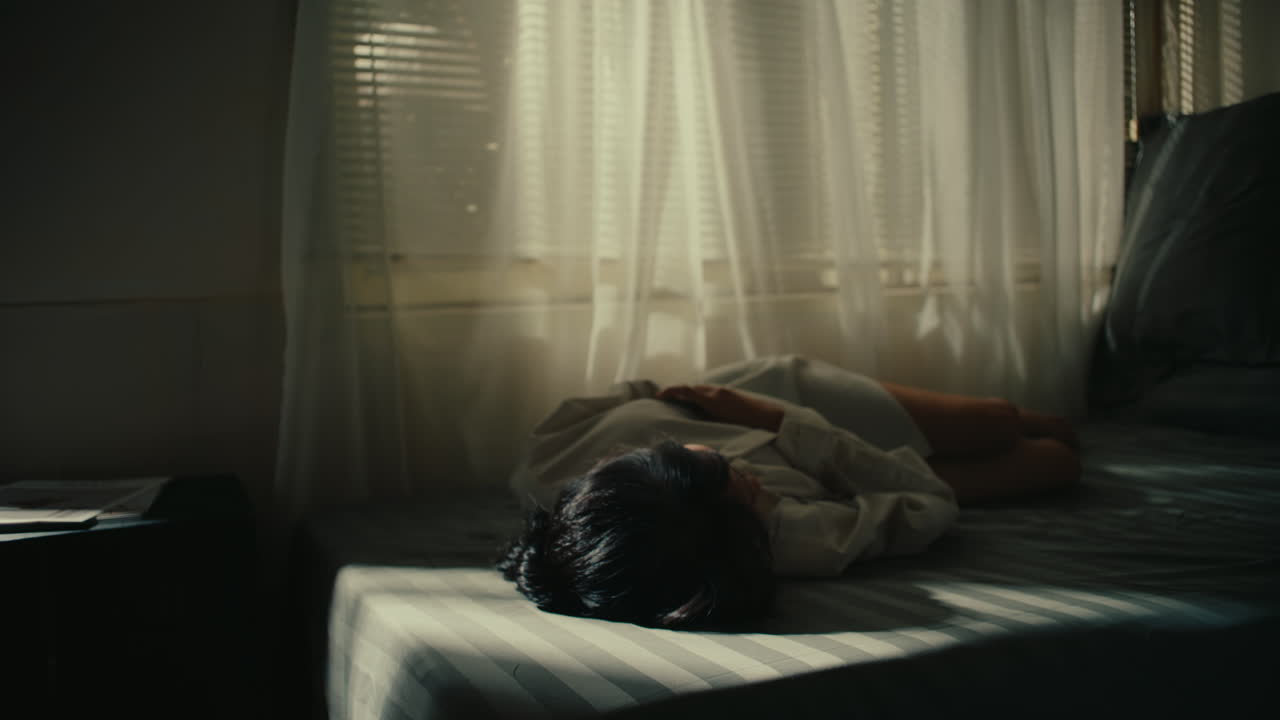 Woman resting in bedroom by window