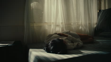 woman resting in bedroom by window