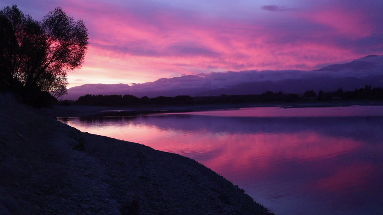 puesta de sol rosada sobre el lago y las montañas nueva zelanda